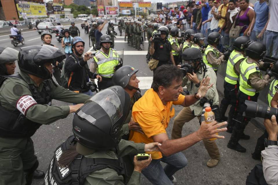 Efectivos de la Guardia Nacional Bolivariana (GNB) forcejean con un manifestante el martes 7 de junio del 2016, en Caracas. CRISTIAN HERNÁNDEZ EFE