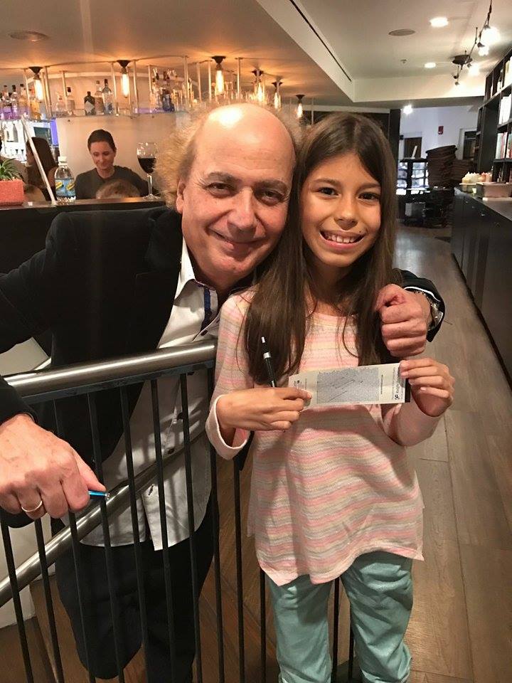 Fabiana, una de las niñas venezolanas que asistió al concierto, con el Maestro Eduardo Marturet quien le autografió la entrada
