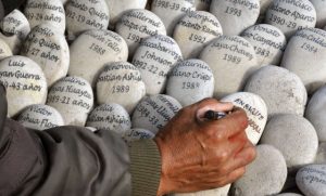 Un hombre escribe en un memorial a las víctimas en Perú. / C. B. (AFP)