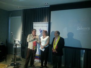 En la apertura del acto, Patricia Andrade entrega la"Bufanda de la Libertad"a los invitados Alberto Ravel y Raúl Leoni